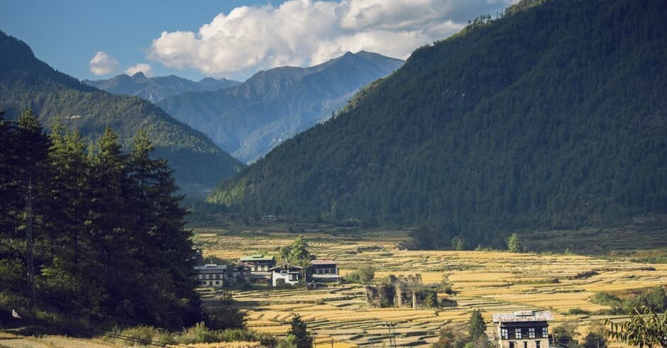 Beautiful mountain valley with rustic village and autumn fields.